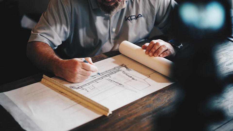 Tecnico al lavoro su disegni e documenti di progetto